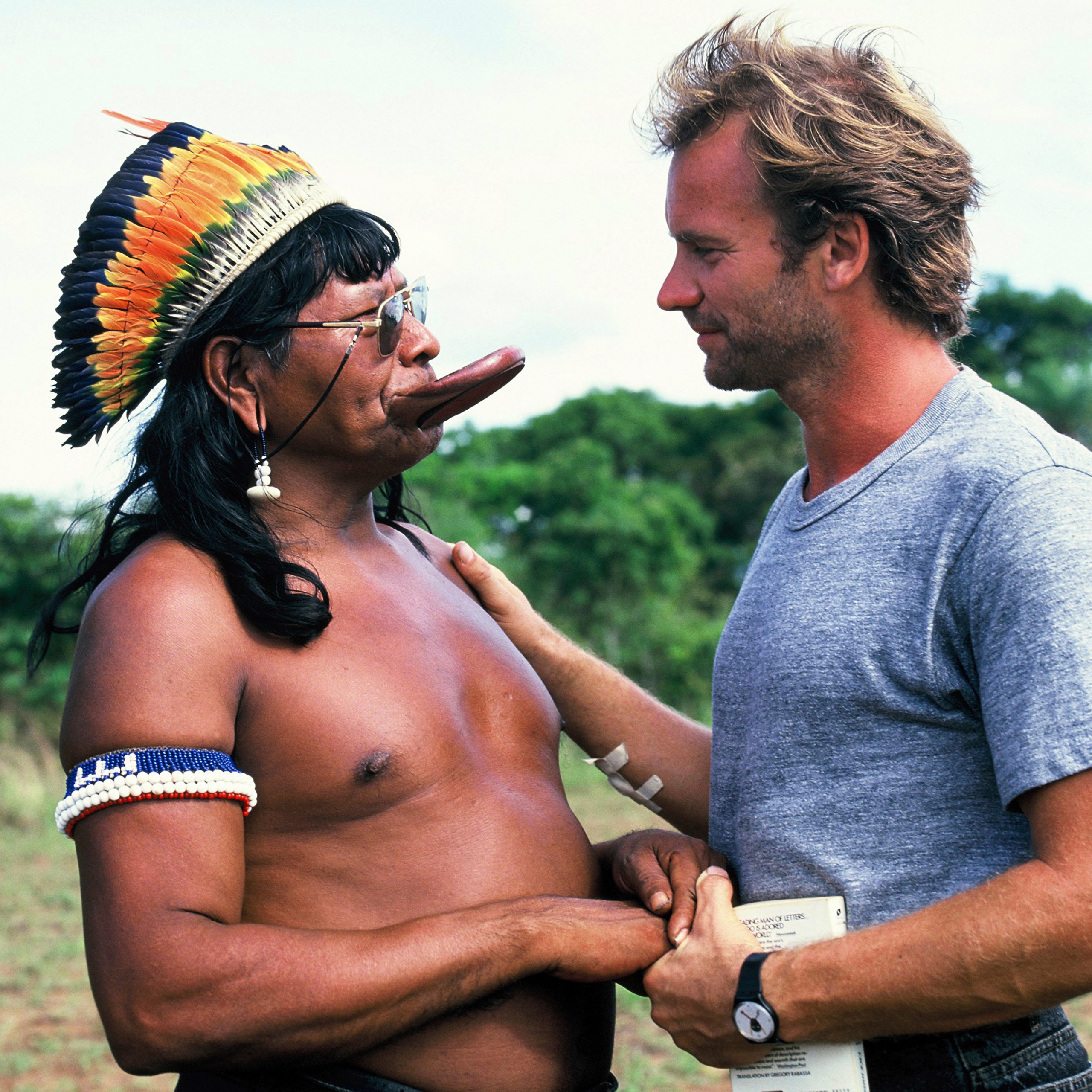 Historical image from the late 1980's of Sting shaking hands with Chief Raoni of the Kayapo people of Brazil