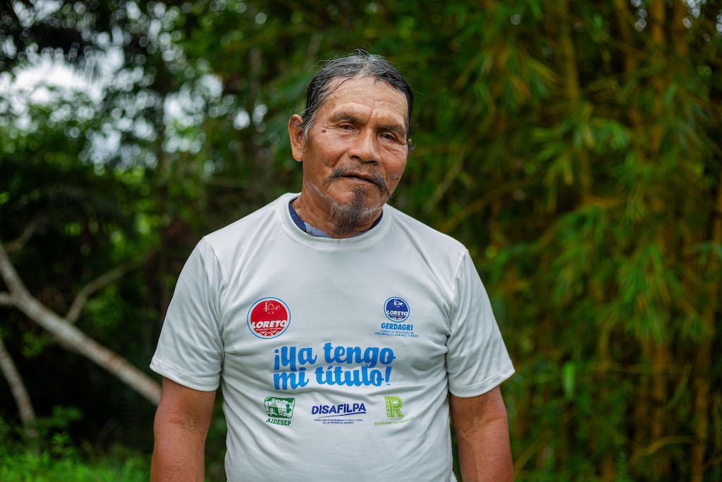 Apu Anibal Oliveira looks at the camera, wearing a t-shirt with the phrase 'I now have my land title.'