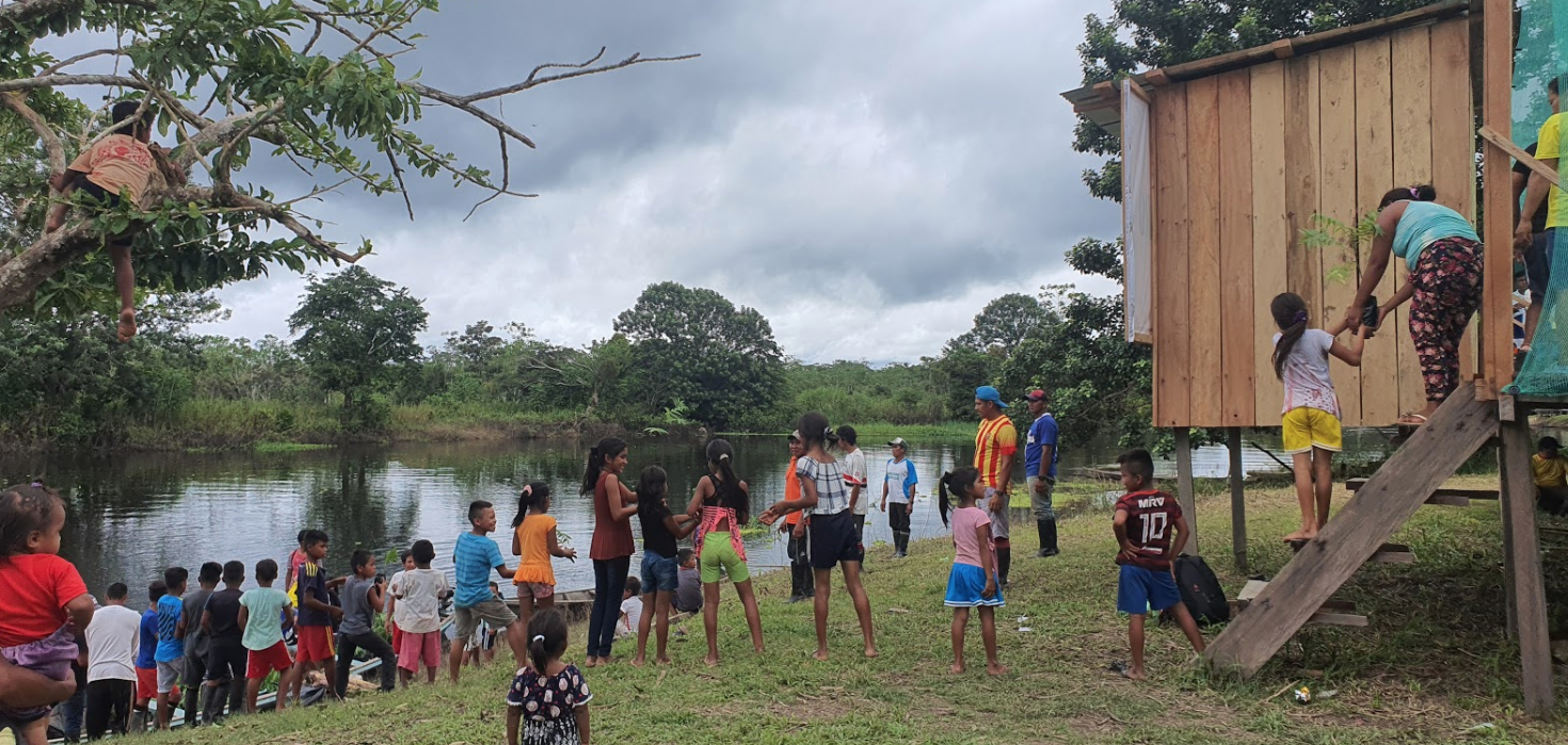 An assembly line of community members transport seedlings from boats to the seedling nursery