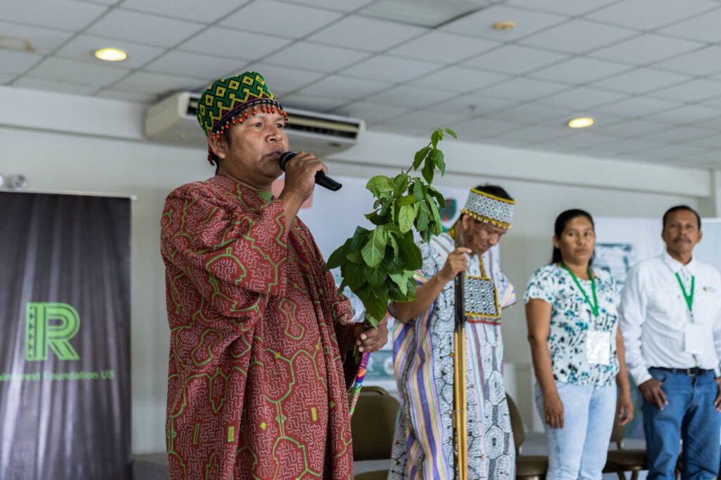 An Indigenous leader, adorned in traditional attire, leads a spiritual opening ceremony during the Tech Camp event.