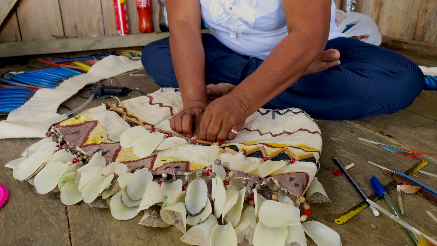 a ticuna artisan dyes a traditional attire using native plants like achiote (annatto)