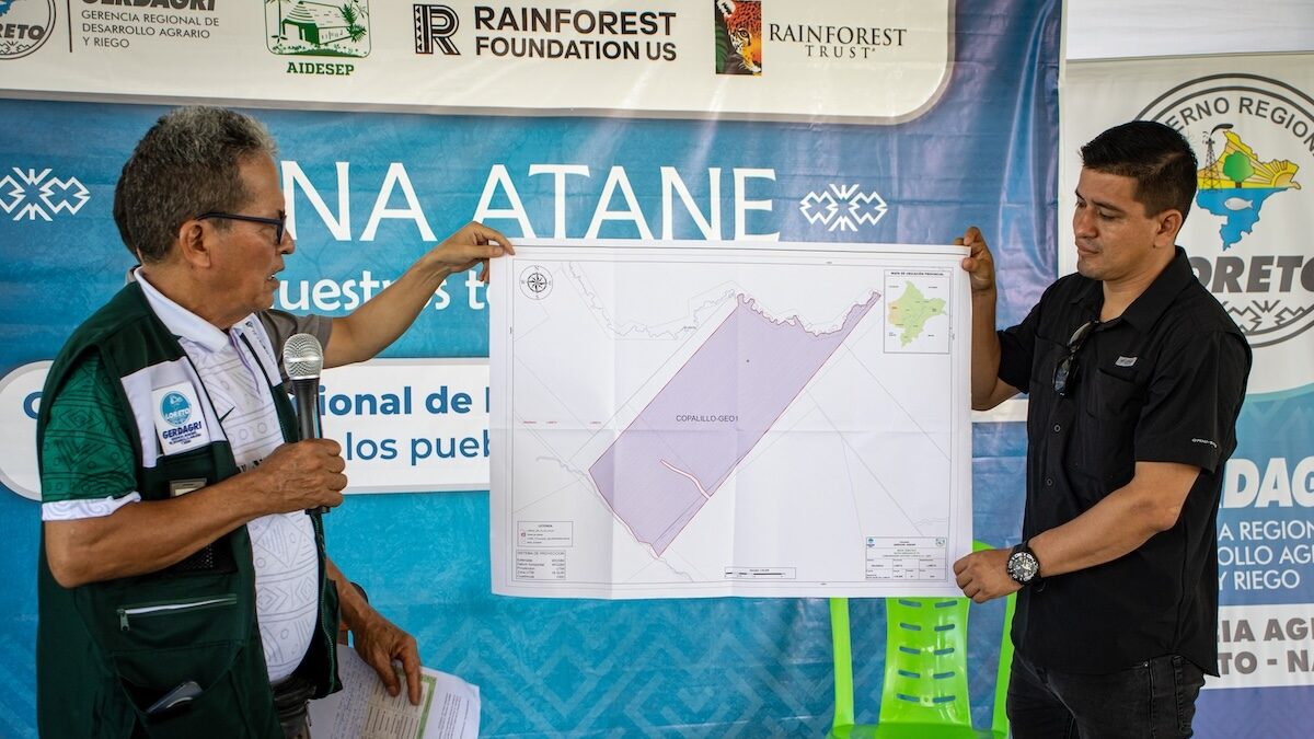 A representative from the regional government of Loreto holds a map of one community that will receive its land title