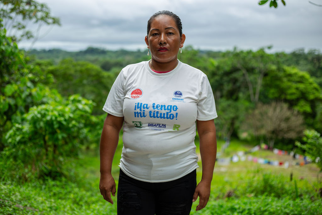 Ticuna leader Elizette Cruz Ponciano looks at the camera, wearing a t-shirt with the phrase 'I now have my land title.'