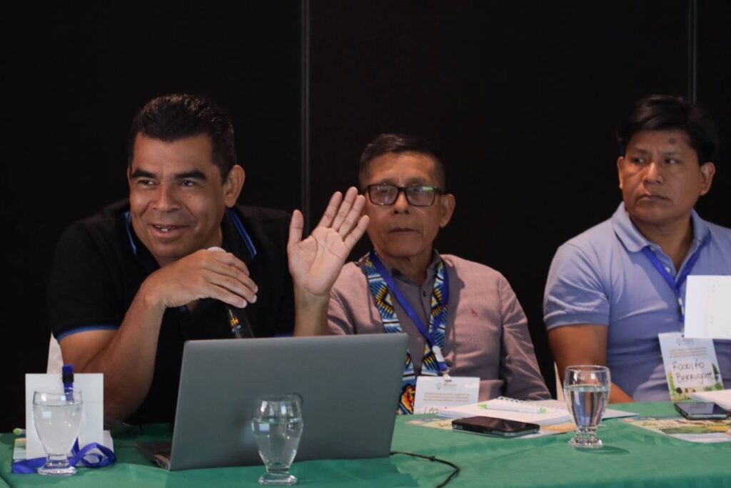 Levi Sucre Romero, Coordinator of the Mesoamerican Alliance of Peoples and Forests (AMPB), sitting next to two community leaders during the event.