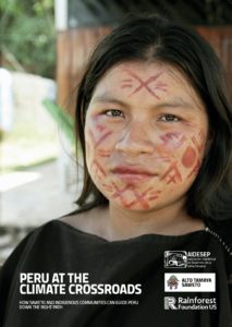 A young indigenous woman stares into the camera, her face painted with red crosses.