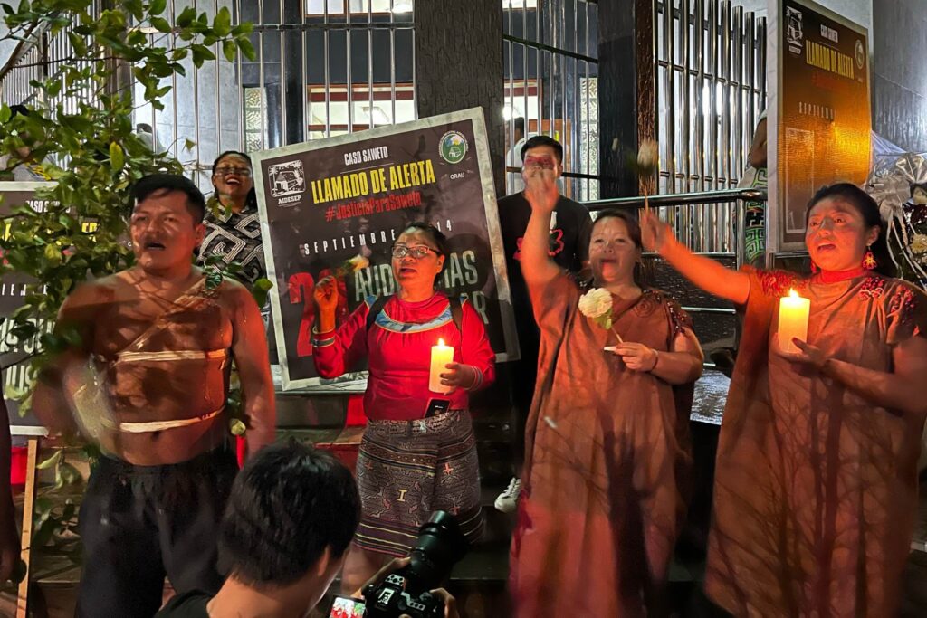 Indigenous community members hold a night vigil with candles and flowers, marking the commencement of the Saweto trial in Peru, November 2023. Their faces reflect a mix of hope and solemnity, embodying the resilience in the fight to protect environmental defenders and their crucial work.