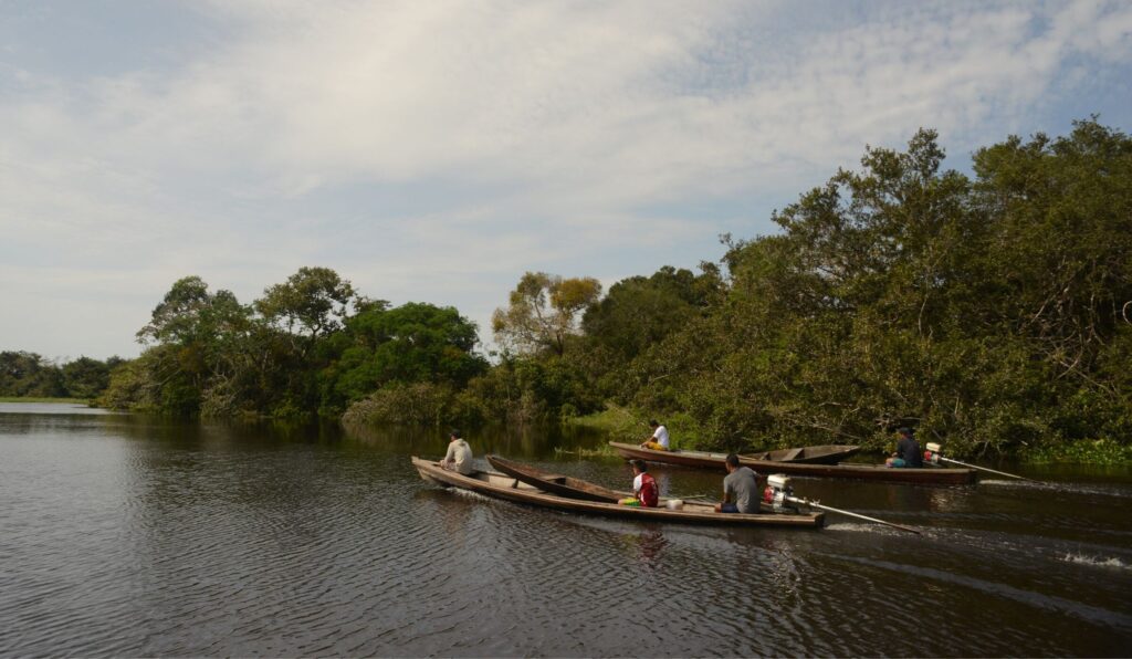 Ticuna people paddle down a river in the Peruvian Amazon. IMAGE CREDIT: Mauricio Velez/RFUS