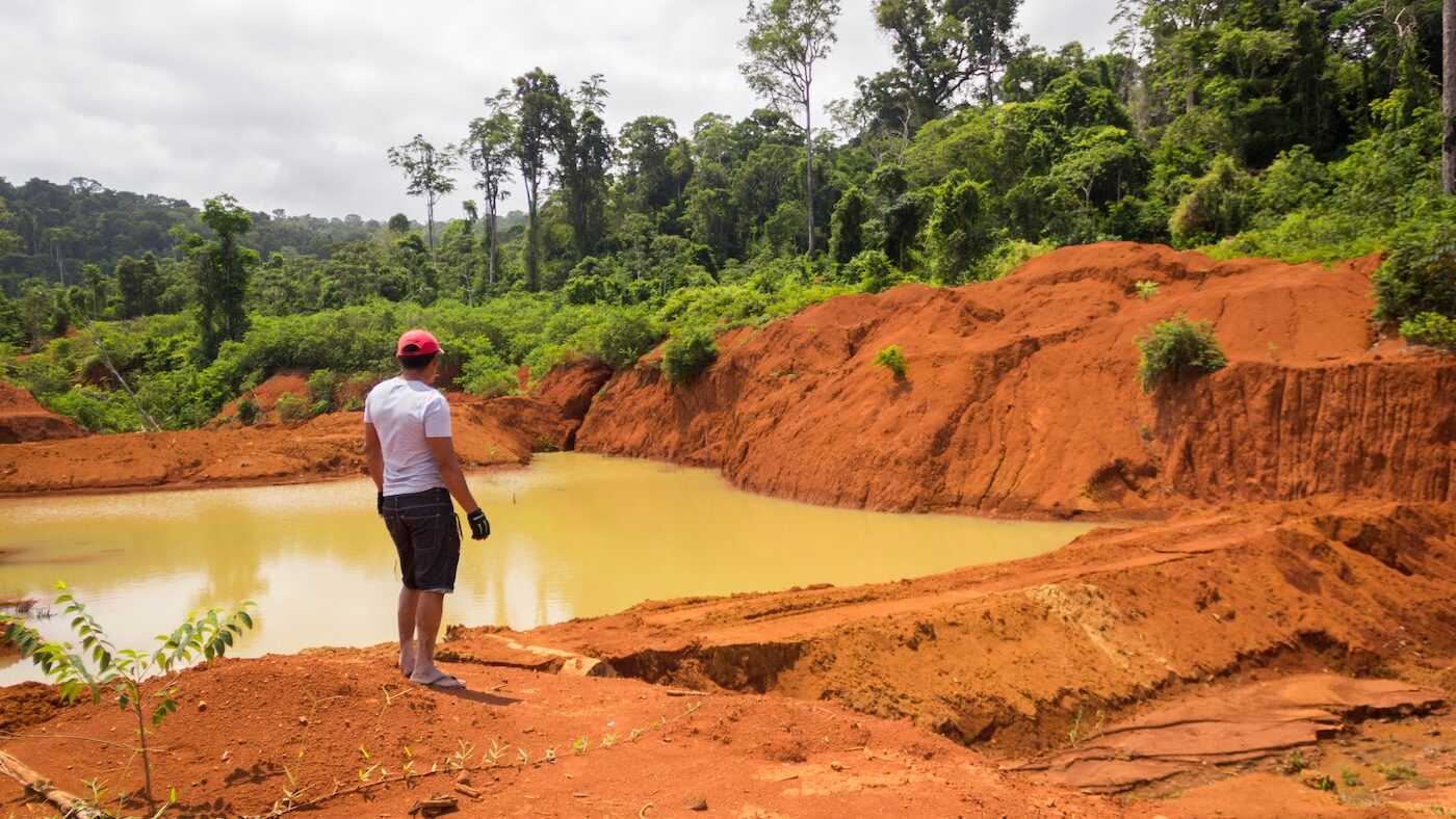 Person overlooking muddy mining site in Guyana's Marudi mine